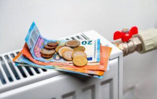 Na kaloryferze leżą euro symbolizujące dopłatę za ciepło.