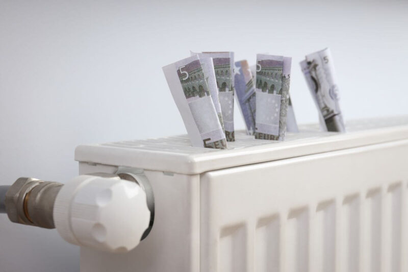 Banknoty euro na kaloryferze symbolizujące dopłatę za c.o.